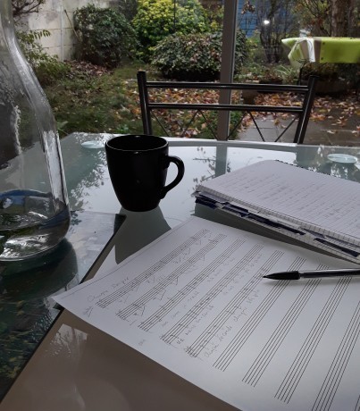 partition manuscrite et un café sur une table